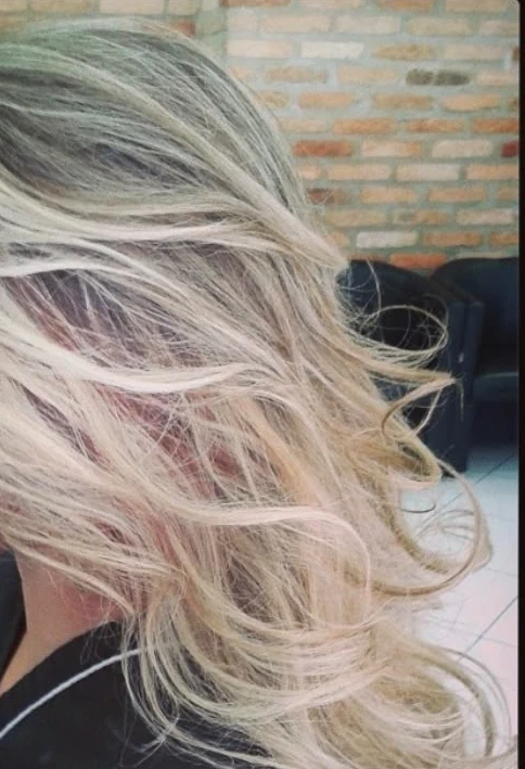 Cabelo loiro com ondas e movimento; enquadramento posterior sem rosto