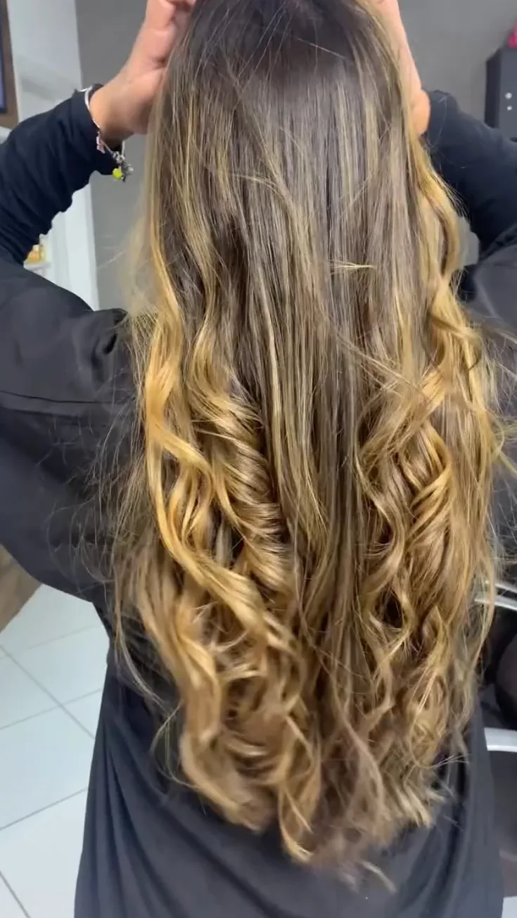Cabelo longo com mechas e ondas visto de trás